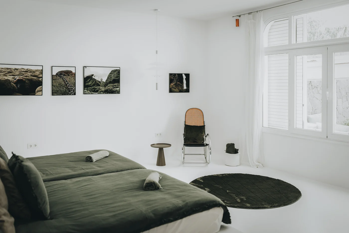 The main bedroom, with green linen and photographs of the island.