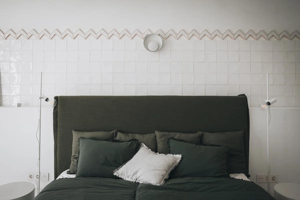 The third bedroom, with natural textures and a green headboard.