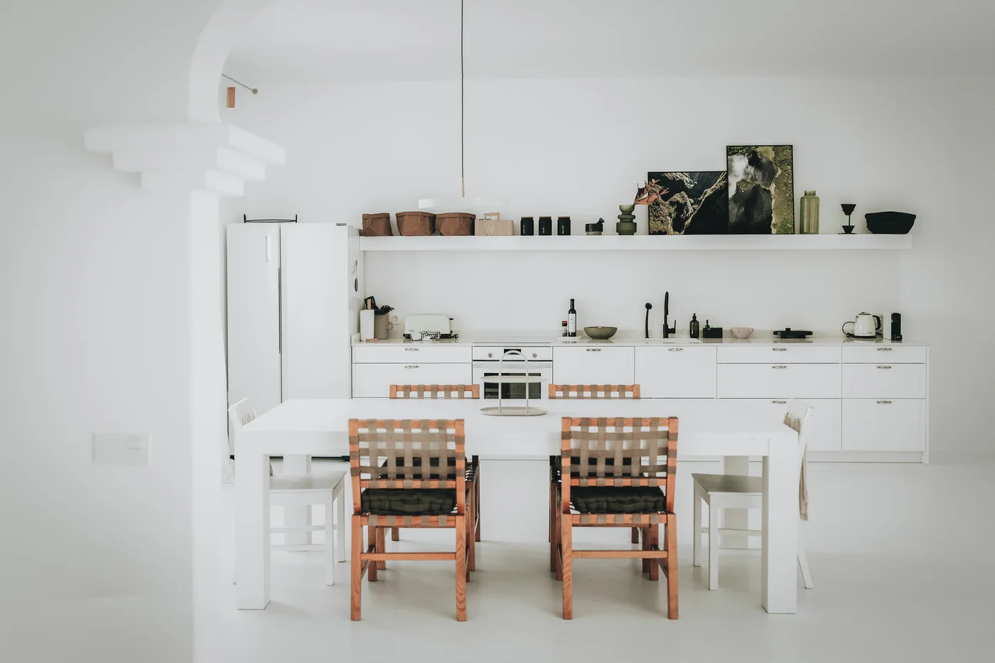 The kitchen and dining area, with a wooden table and white cabinetry.