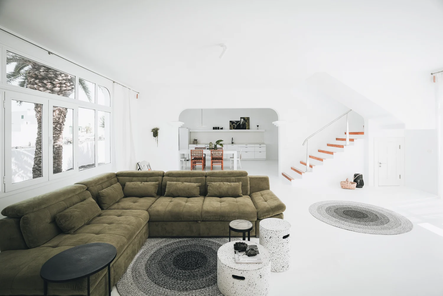 An olive-green sofa, white walls and room to gather.