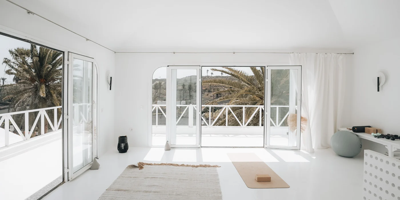 The bright studio opens towards the palms.