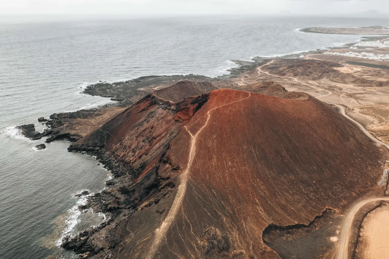 Red volcanic slopes beside the Atlantic.