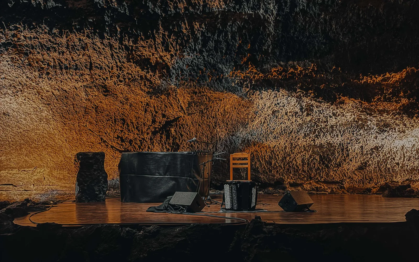Musical instruments on a stage within volcanic rock.