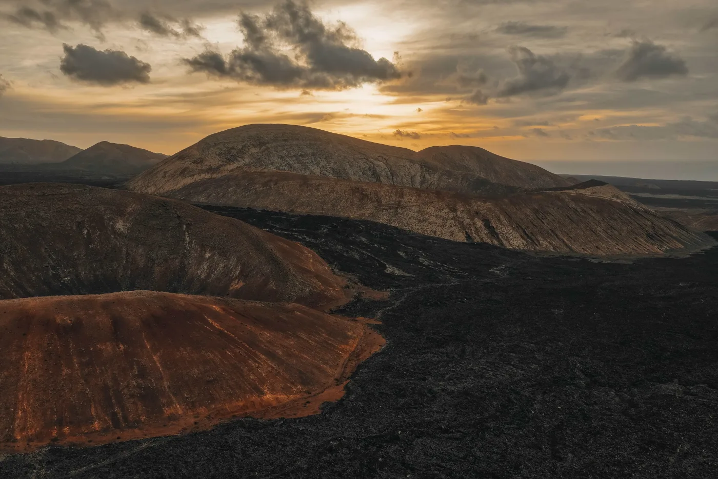 Volcanic craters and lava fields around Caldera Blanca at sunset.